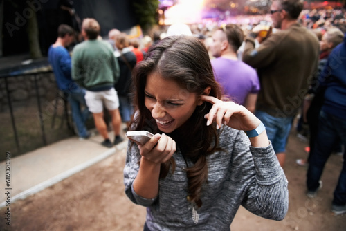 Music festival, event and woman outdoor with phone call, conversation and noise from concert, crowd or party. Contact, person and confused by loud, sound or listening to smartphone and lost at a rave