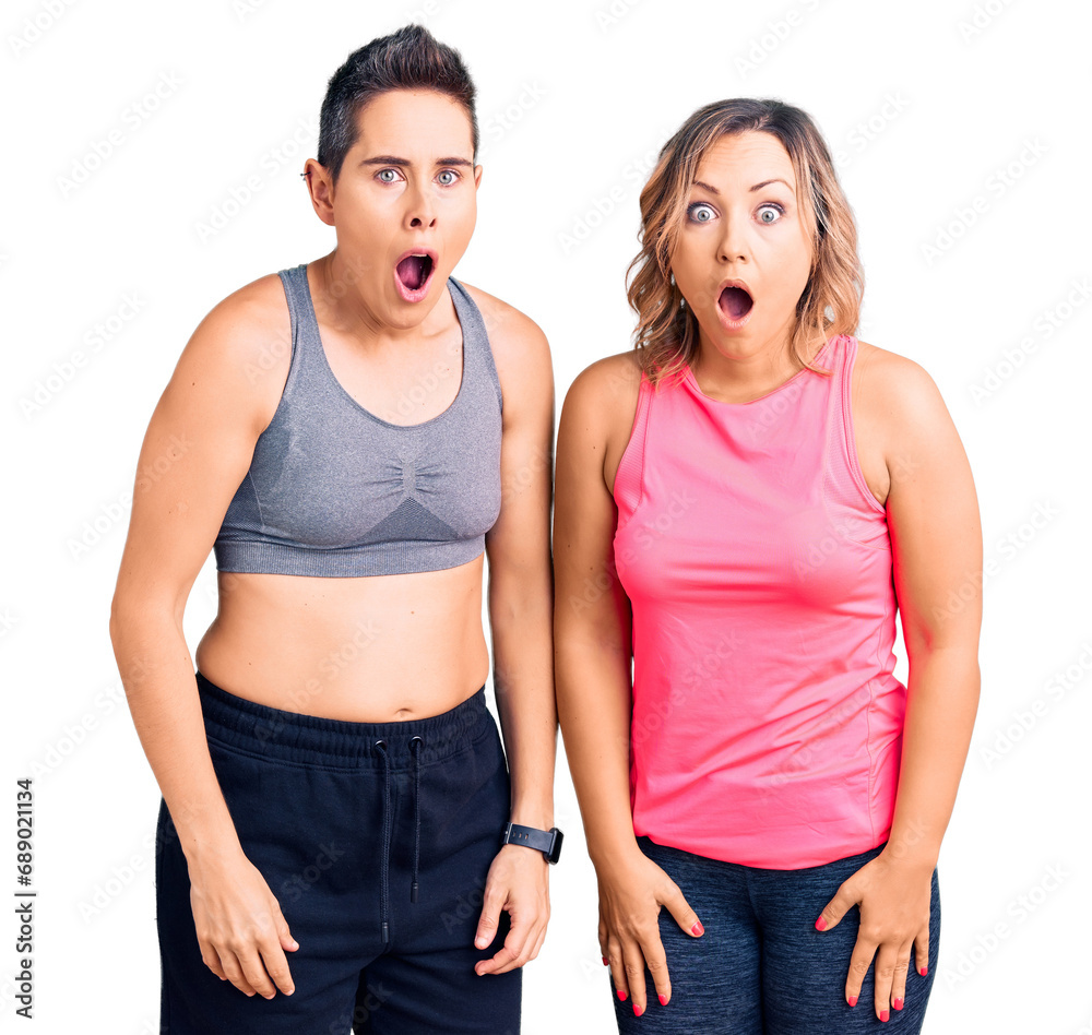 Couple of women wearing sportswear afraid and shocked with surprise and amazed expression, fear and excited face. Couple of women wearing sportswear afraid and shocked with surprise and amazed expression, fear and excited face.