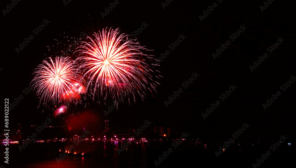 Stunning gradient scarlet fireworks splashing in the night sky over the harbor Stunning gradient scarlet fireworks splashing in the night sky over the harbor