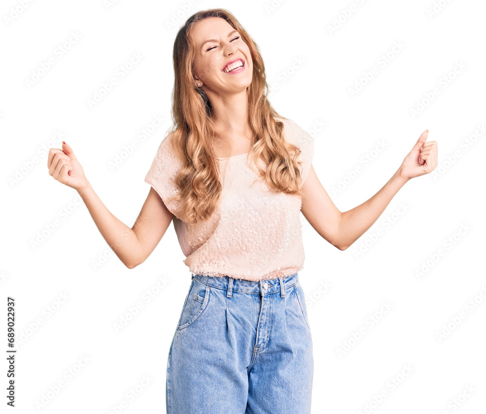 Young beautiful caucasian woman with blond hair wearing casual clothes very happy and excited doing winner gesture with arms raised, smiling and screaming for success. celebration concept. Young beautiful caucasian woman with blond hair wearing casual clothes very happy and excited doing winner gesture with arms raised, smiling and screaming for success. celebration concept.