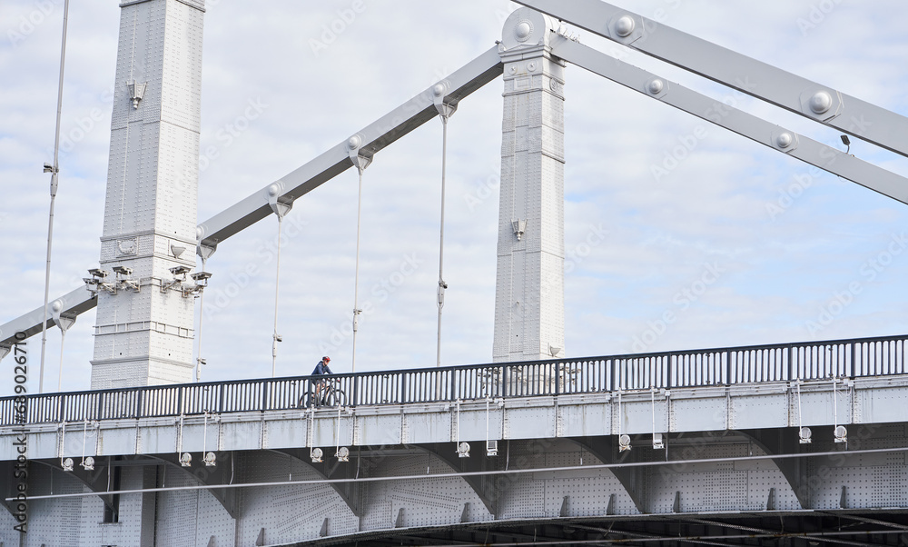 Man riding on bicycle across the bridge in the city. Man riding on bicycle across the bridge in the city.