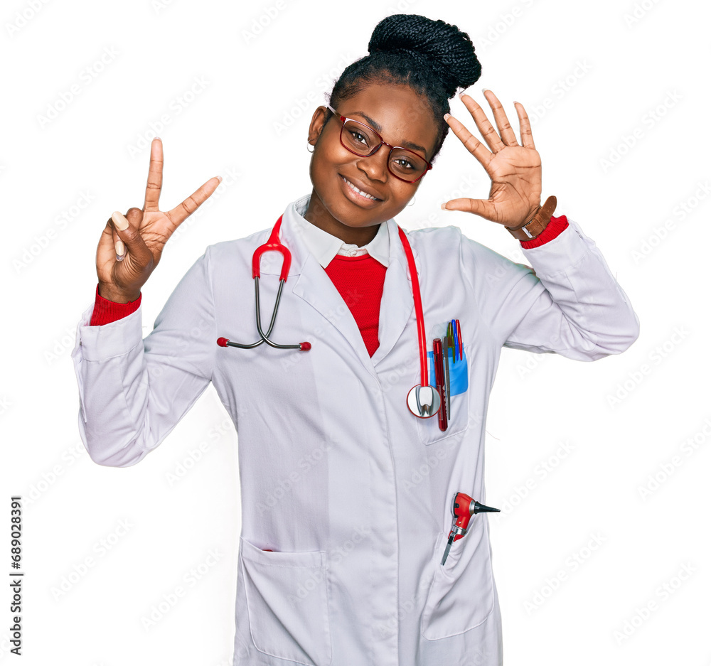 Young african american woman wearing doctor uniform and stethoscope showing and pointing up with fingers number seven while smiling confident and happy. Young african american woman wearing doctor uniform and stethoscope showing and pointing up with fingers number seven while smiling confident and happy.