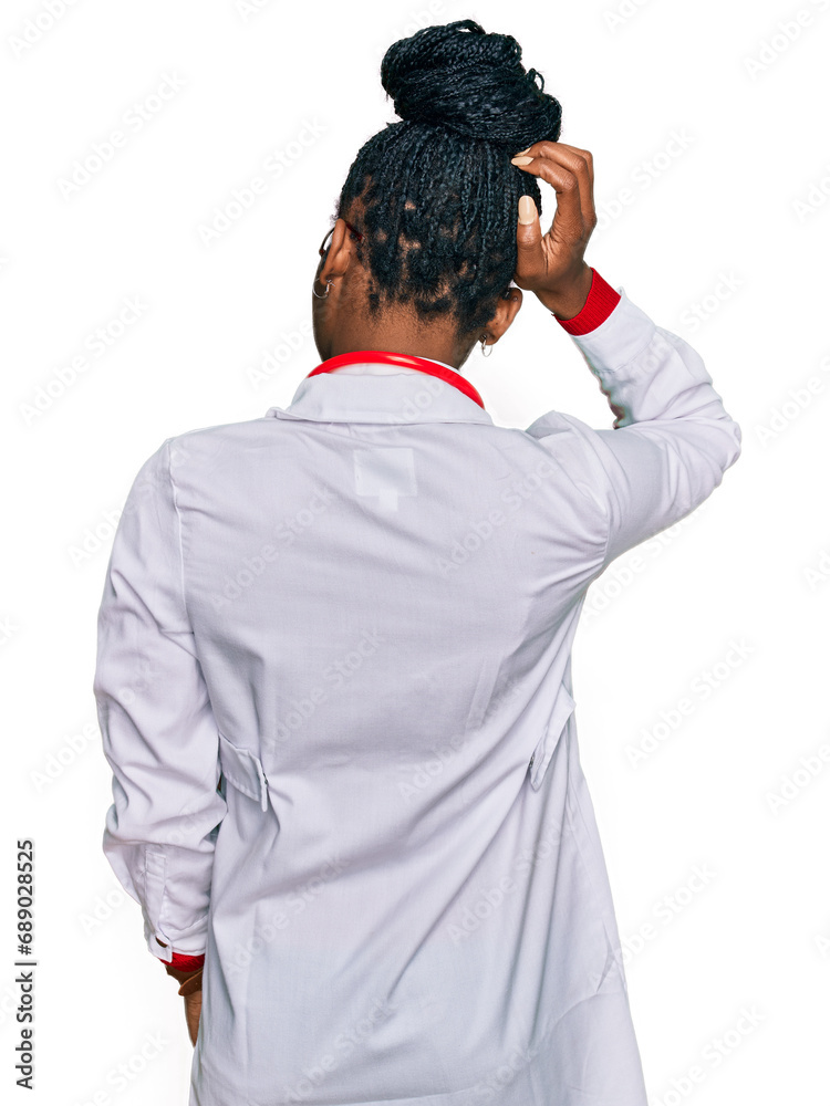 Young african american woman wearing doctor uniform and stethoscope backwards thinking about doubt with hand on head Young african american woman wearing doctor uniform and stethoscope backwards thinking about doubt with hand on head