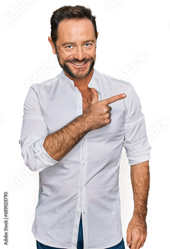 Middle age man wearing casual clothes cheerful with a smile of face pointing with hand and finger up to the side with happy and natural expression on face