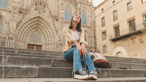Photography Happy girl traveler resting while sitting on the steps of an old building in the