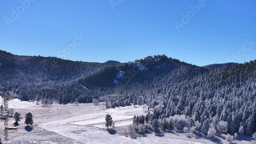 Cold iced melting field open space white sunny December winter Christmas Xmas frosted Aspen trees forest first snow aerial cinematic drone bluebird Evergreen Colorado Rocky Mountain scene slow upward photo