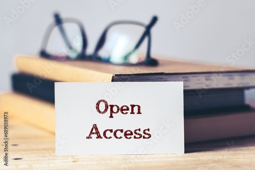 White card with the note Open Access on desk. Selective focus, open online access of academic information and research publications.