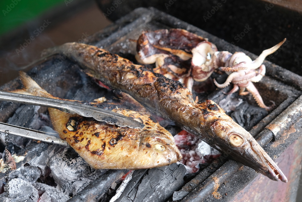 grouper, pomfret, barracuda, squid grilled on a charcoal grill. grilled sea fish. Indonesian food. ikan kerapu, bawal, cucut, dan cami bakar. grouper, pomfret, barracuda, squid grilled on a charcoal grill. grilled sea fish. Indonesian food. ikan kerapu, bawal, cucut, dan cami bakar.