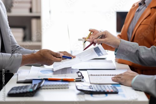 Close up Team of colleagues discussing business Accounting using calculating income-expenditure and calculator analyzing real estate investment data report Financial and tax systems concept.