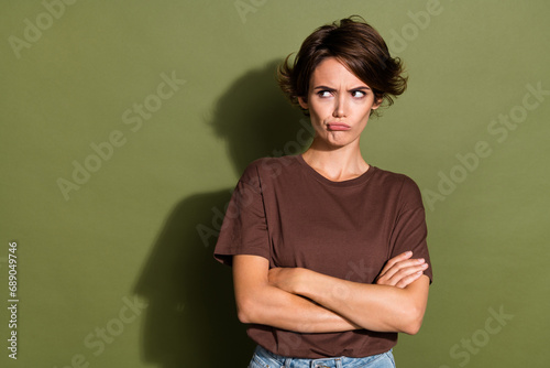 Photo of upset gloomy offended woman with bob hair dressed brown t-shirt arms crossed look empty space isolated on khaki color background photo