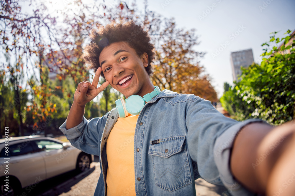 Φωτογραφία Photo of funky cheerful guy dressed jeans shirt headphones showing v-sign cover