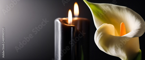 Candela Nera Accesa con Fiori Calla su Sfondo Nero, concetto di funerale photo