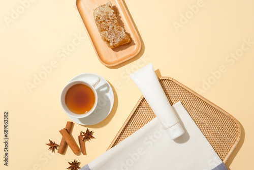 Unbranded tube displayed with a cup of tea and wooden dish of beeswax. Raw honey contains many important antioxidants. Star anise and cinnamon featured