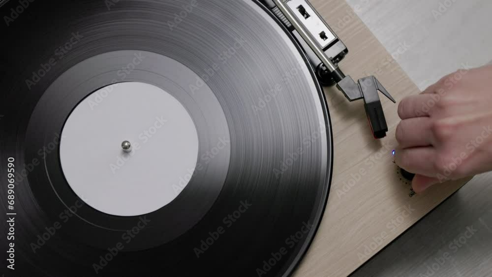 Top view of hand turns on a vintage vinyl record