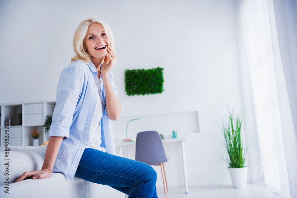 Photo portrait of charming retired woman sit sofa touch skin laugh weekend stylish home decor living room modern apartment Photo portrait of charming retired woman sit sofa touch skin laugh weekend stylish home decor living room modern apartment