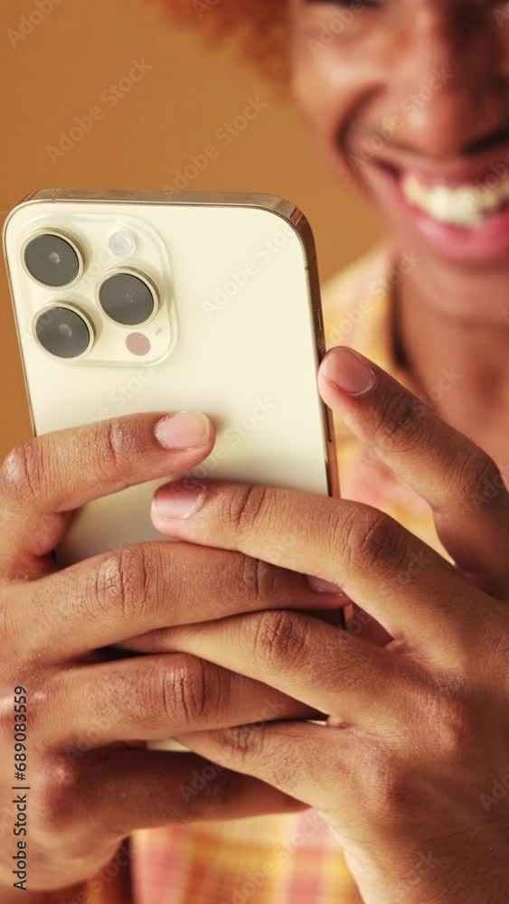 Close-up, guy's hands holding mobile phone, isolated on brown background Close-up, guy's hands holding mobile phone, isolated on brown background