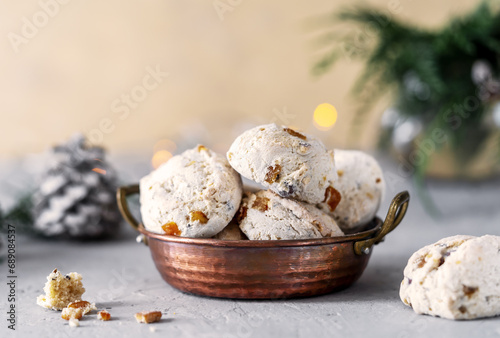 Italian traditional Christmas sweets Cavallucci in a rustic copper bowl over grey and light yellow background with xmas decor