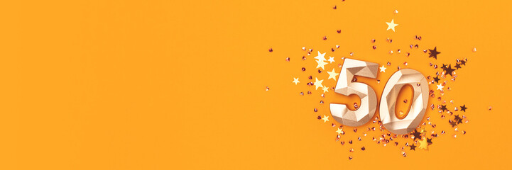 Banner with golden number fifty and stars confetti on a yellow background. Festive concept with place for text.