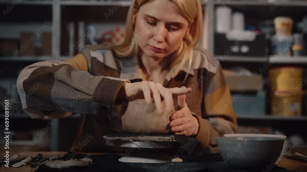 Female ceramist making handmade pottery cup or clay pot. Young woman potter wearing warm plaid shirt shaping craft tableware in pottery studio. Working process sculpting modeling in ceramic workshop Female ceramist making handmade pottery cup or clay pot. Young woman potter wearing warm plaid shirt shaping craft tableware in pottery studio. Working process sculpting modeling in ceramic workshop