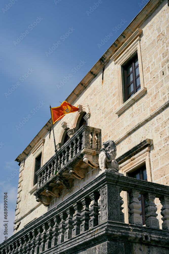 Flag of Montenegro flutters on the stone balcony of an ancient building