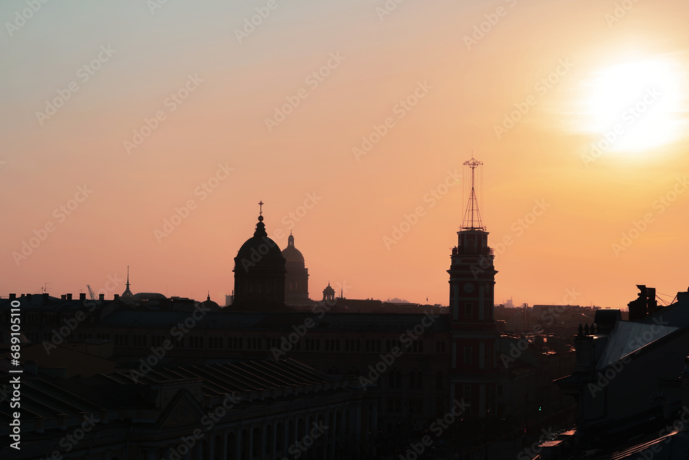 Panoramic view of the roofs, towers, domes of churches and cathedrals silhouetted against sunset light. Saint-Petersburg, Russia. Traveling and tourism concept. Copy space.