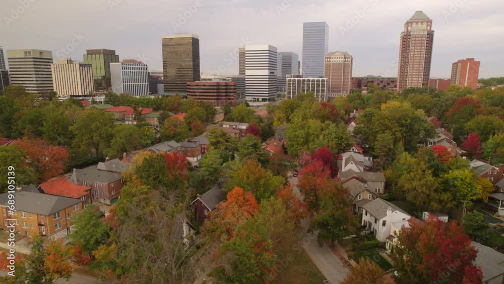 Aerial flyover beautiful historic Clayton neighborhood homes with downtown city skyline on the horizon in the Fall. Aerial flyover beautiful historic Clayton neighborhood homes with downtown city skyline on the horizon in the Fall.