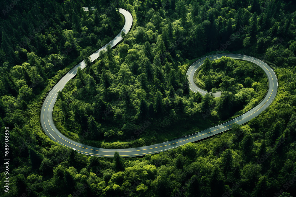 Aerial view of the road in the forest at sunset. Aerial view of a winding road in the middle of the forest Aerial view of the road in the forest at sunset. Aerial view of a winding road in the middle of the forest