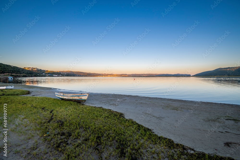 Knysna Lagoon with jetty and fishing boats at sunset in the Garden Route South Africa
