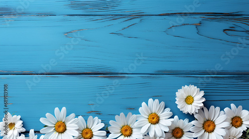Daisy summer flowers on blue wood background for advertising © Tendofyan
