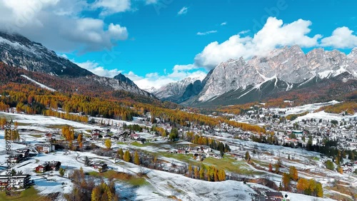 Aerial drone view of valley, snowy villages, autumn forest, Dolomites mountains Italy. High quality 4k footage