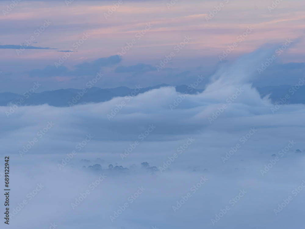 Morning mist flows through the mountains.