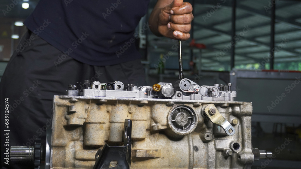 person unscrewing gearbox in the factory person unscrewing gearbox in the factory