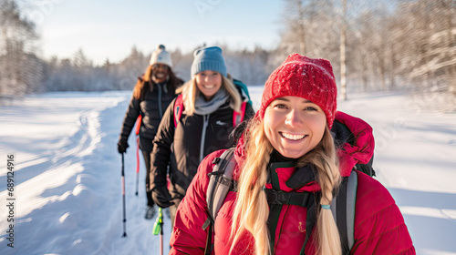 Cheerful friends with backpacks for hike walking across winter forest exploring nature. Friends active lifestyle spending time together without using gadgets.
