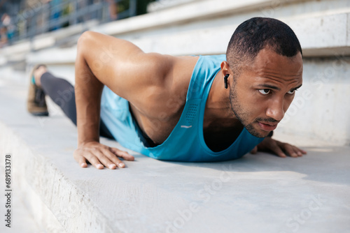 Sportsman doing push ups and looking concentrated