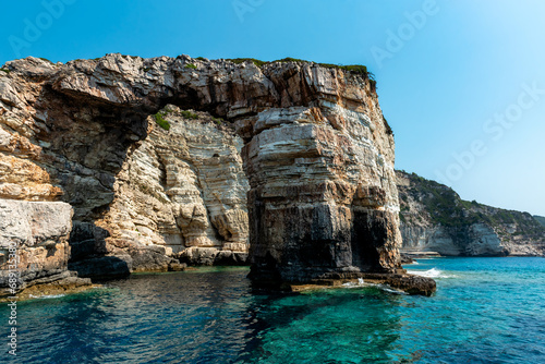 Scene of Rock Cliff in the Sea with Blue Sky and Turquoise Water. Beautiful Day at Antipaxos Island in Greece.