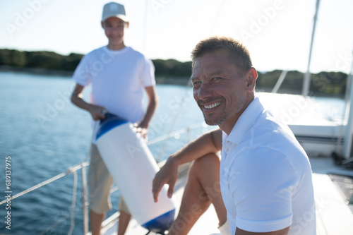Son and dad yachting and looking happy and contented
