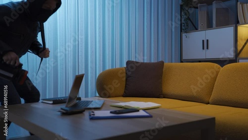 Thief steals money and laptop at night.