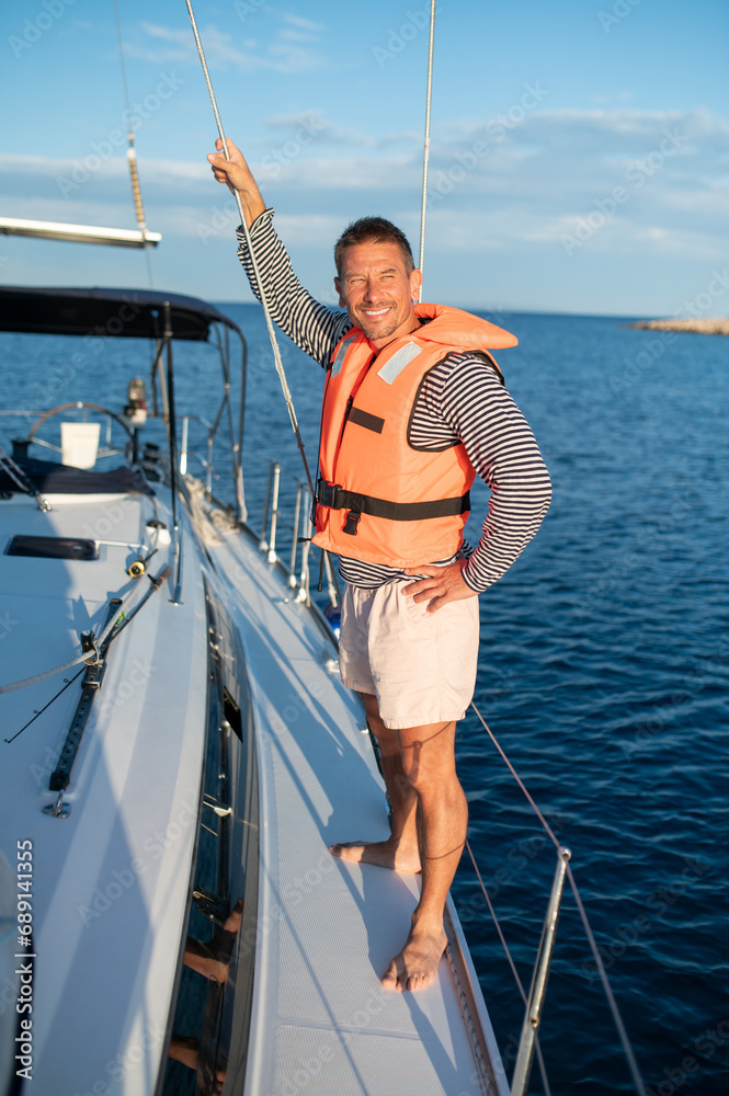 Man on a yacht smiling and feeling peaceful Man on a yacht smiling and feeling peaceful