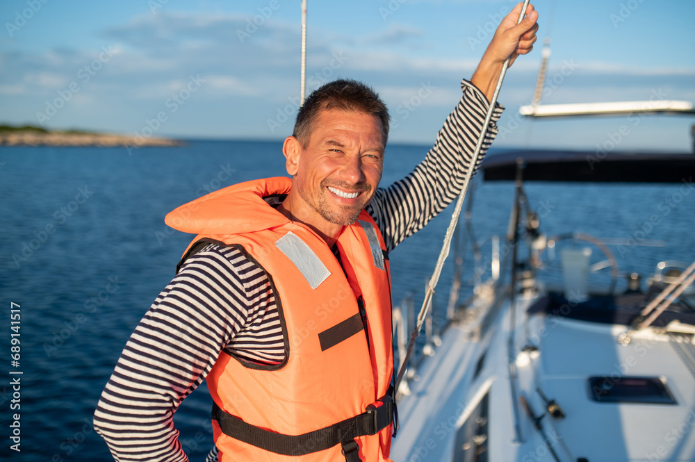 Man on a yacht smiling and feeling peaceful Man on a yacht smiling and feeling peaceful