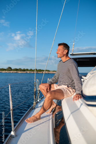 Man on a yacht smiling and feeling peaceful