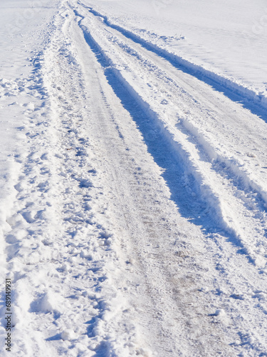 Ruts from car wheels in a snowy field © Juri