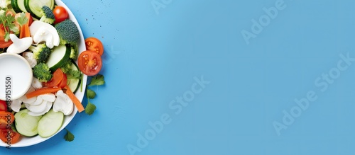 Kitchen compost bin with peeled vegetables on blue background Top view Recycling concept for sustainable and zero waste Copy space image Place for adding text or design photo