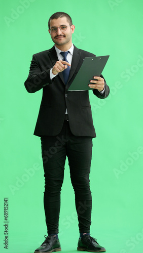 young man in full growth. isolated on green background looking at paper report