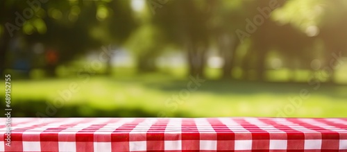 Checkered tablecloth in red on the lawn Copy space image Place for adding text or design