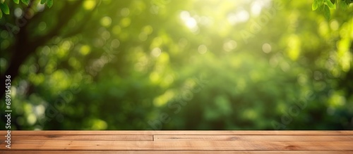 Nature themed background with a wooden table in a garden featuring bokeh in a spring summer setting The wood surface is versatile serving as a shelf counter desk and for picnic meals and produc photo