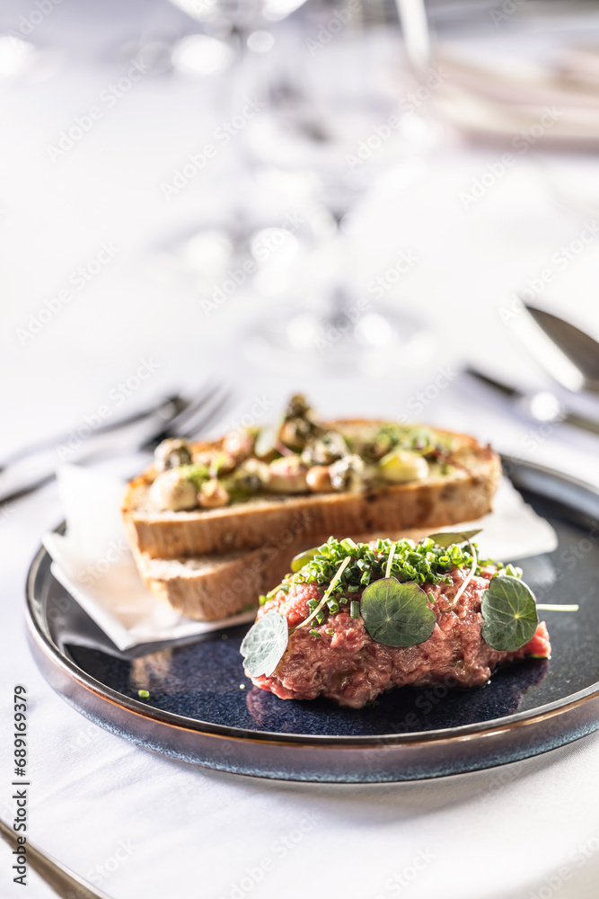Steak Tartare with bread toasts served on a restaurant table Steak Tartare with bread toasts served on a restaurant table