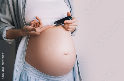 Gestational diabetes test during pregnancy. Pregnant woman checking blood sugar level with glucometer. photo