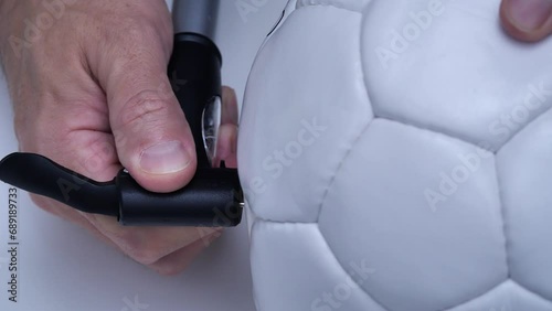 man pumping up a volleyball ball photo