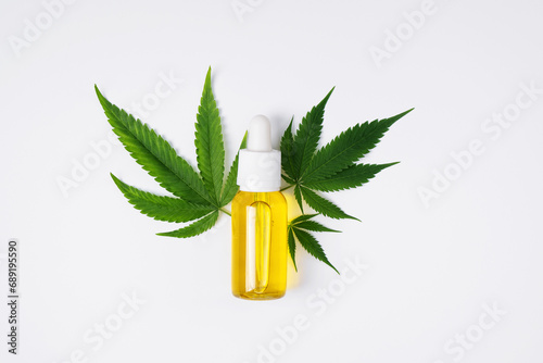 Cannabis oil and hemp leaf on white background, flat lay. Hemp CBD oil  for skin care. photo