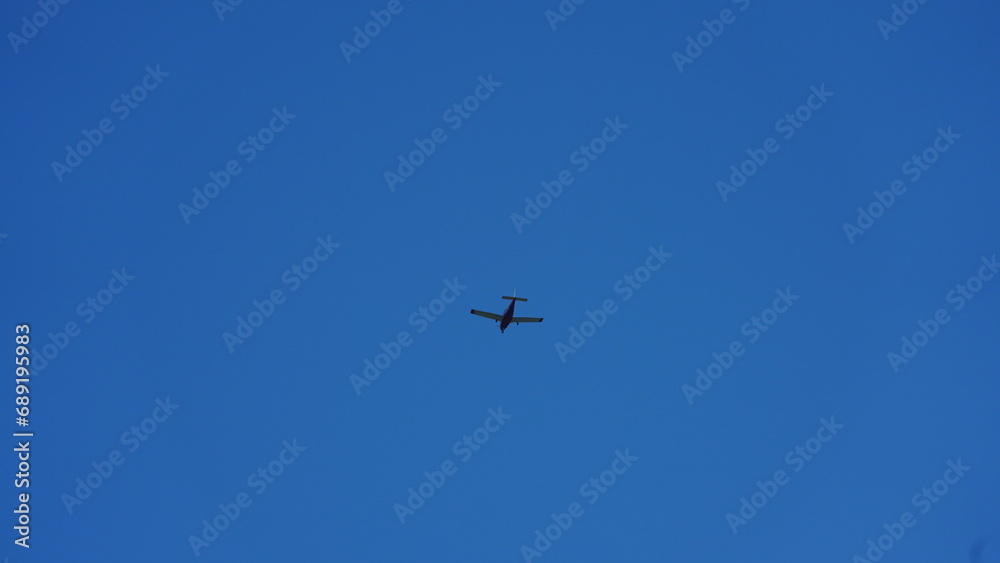 An airplane flying through the clear blue sky in the sunny day An airplane flying through the clear blue sky in the sunny day